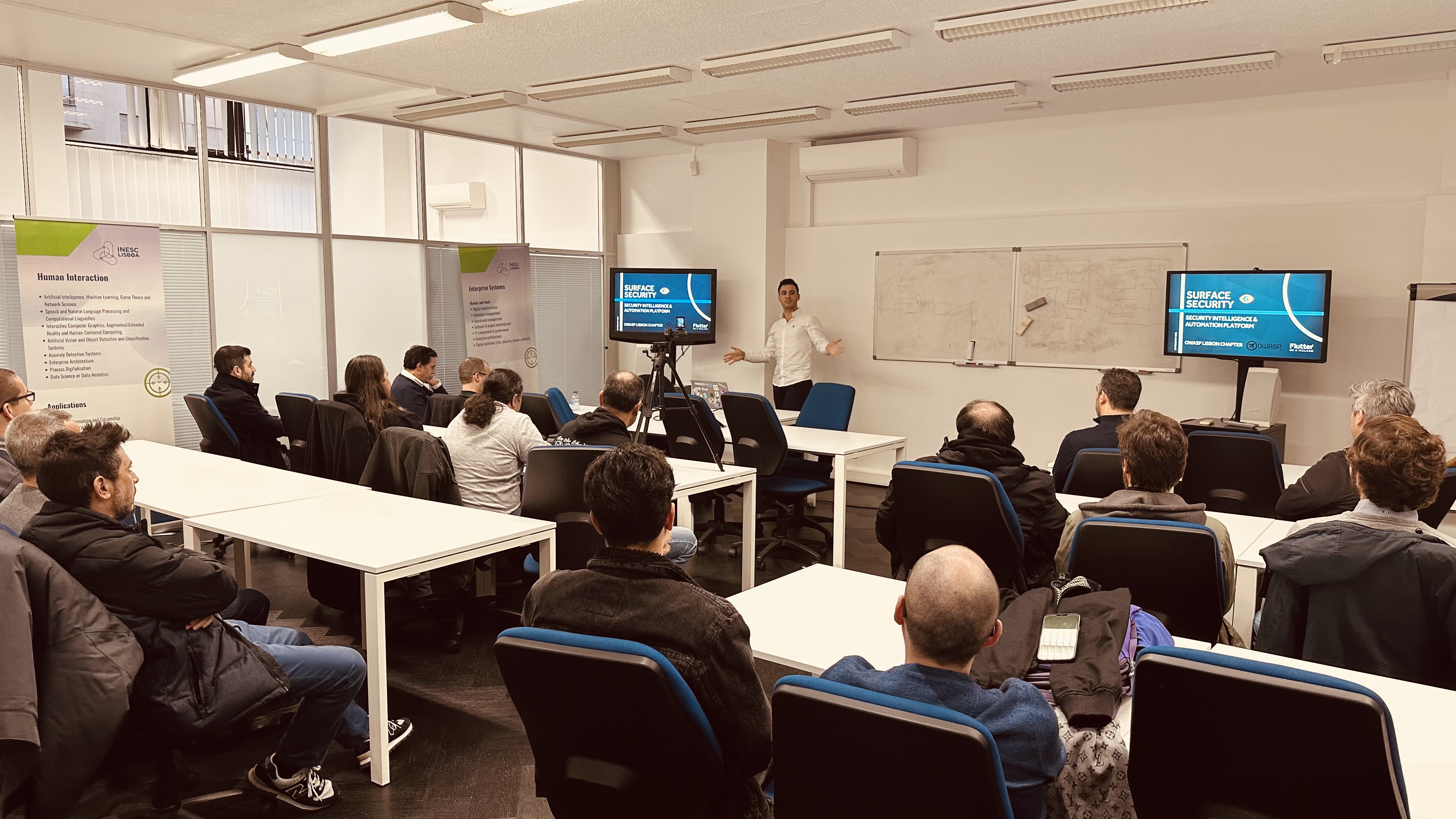 OWASP Lisboa #2 A speaker in a white shirt gestures with open arms while presenting a slide titled ""Surface Security".