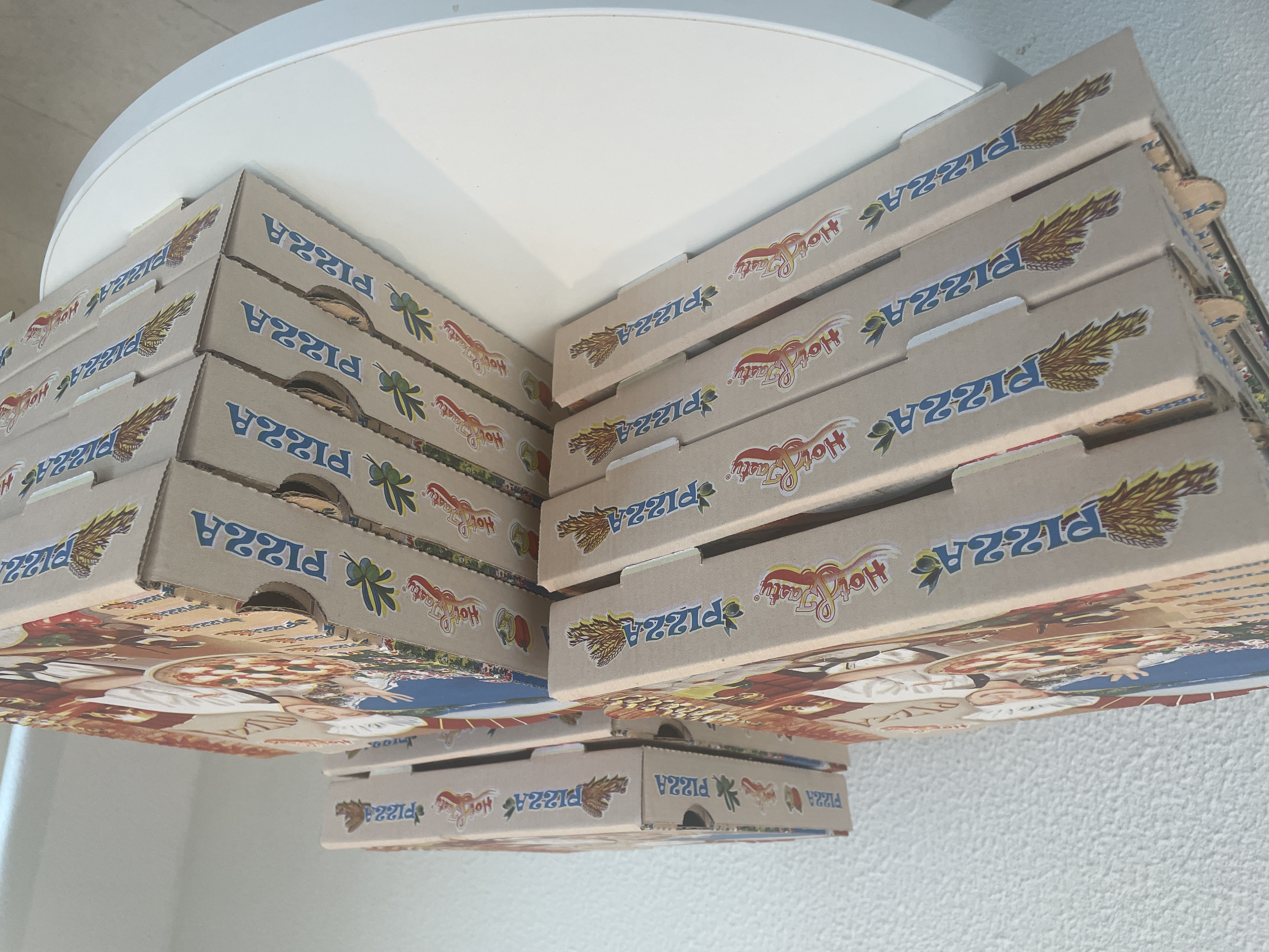 OWASP Lisboa #3 Several stacks of pizza boxes placed on a white round table, ready for the event attendees.