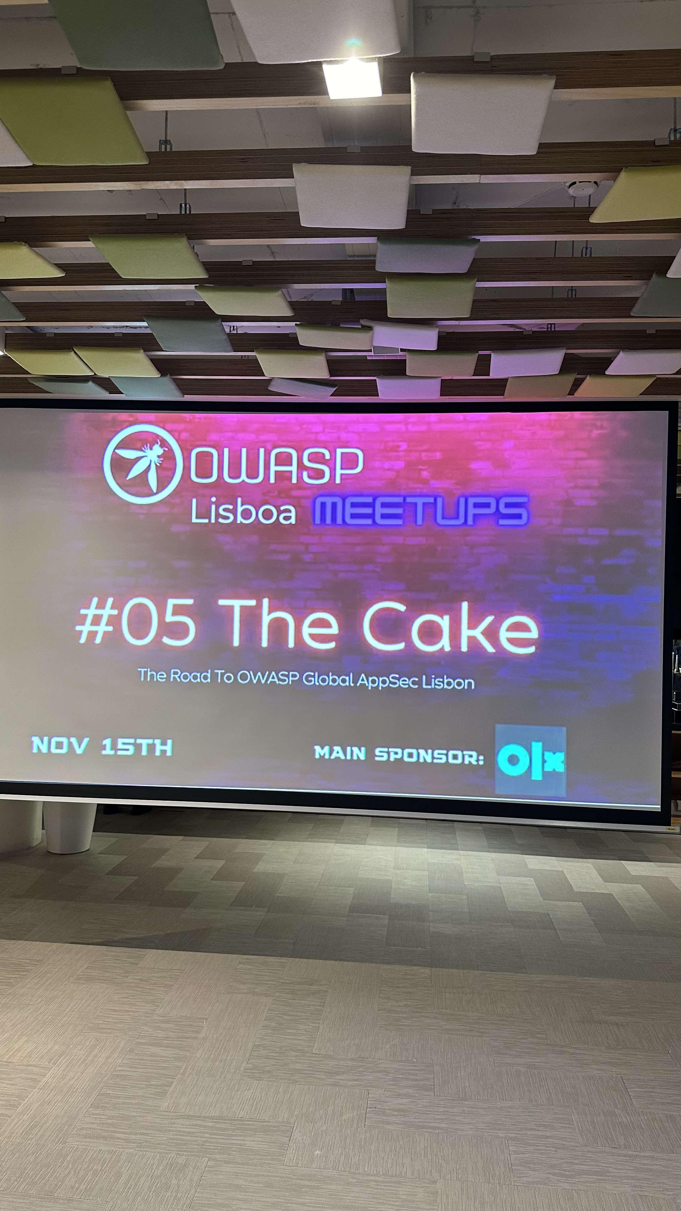 OWASP Lisboa #5 A projection screen displaying the "OWASP Lisboa Meetups #05 The Cake" title slide with the date November 15th and the OLX sponsor logo.