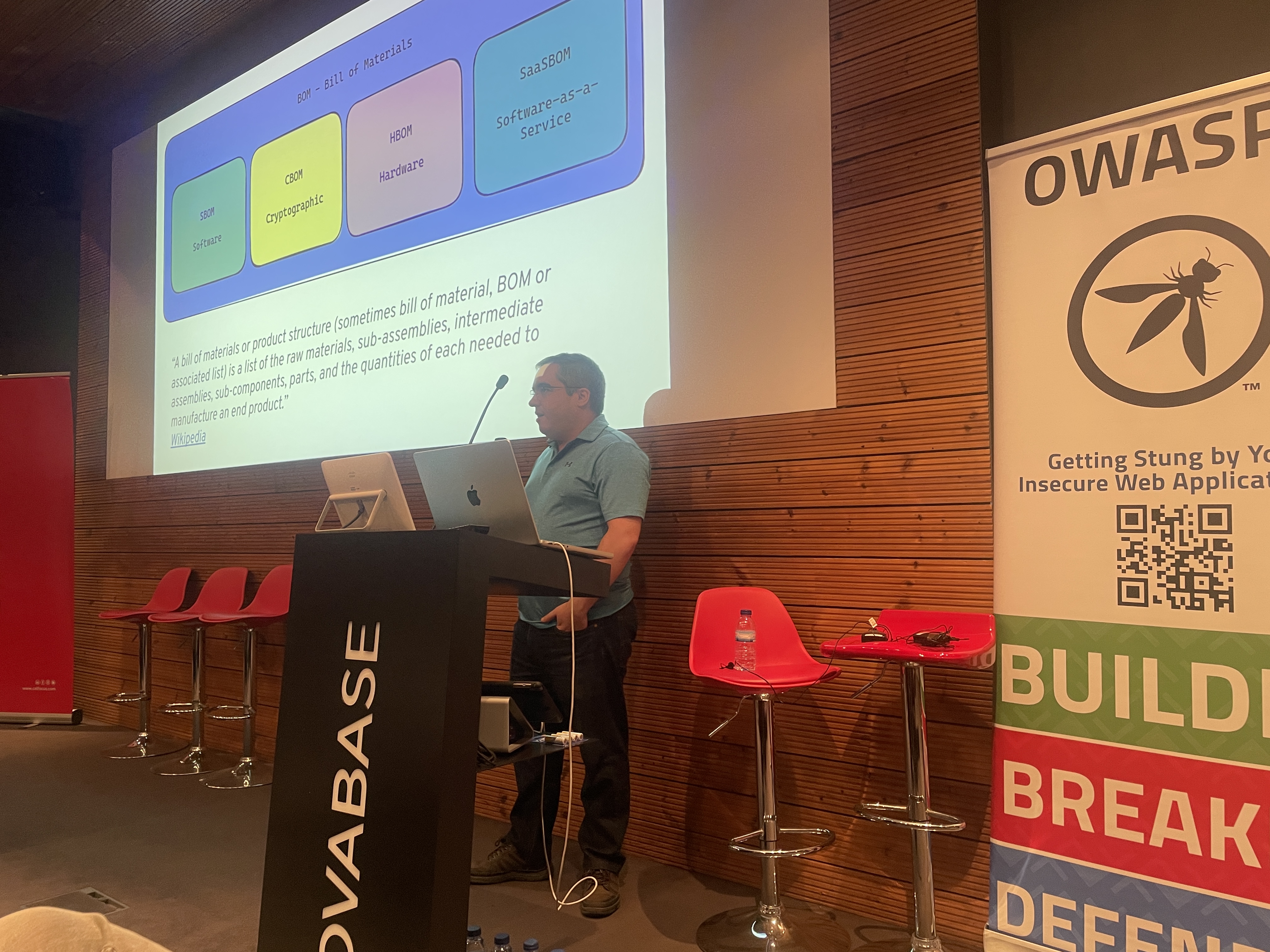OWASP Lisboa #6 A speaker explaining a "Bill of Materials" diagram on the screen, detailing SBOM, HBOM, and SaaSBOM concepts.