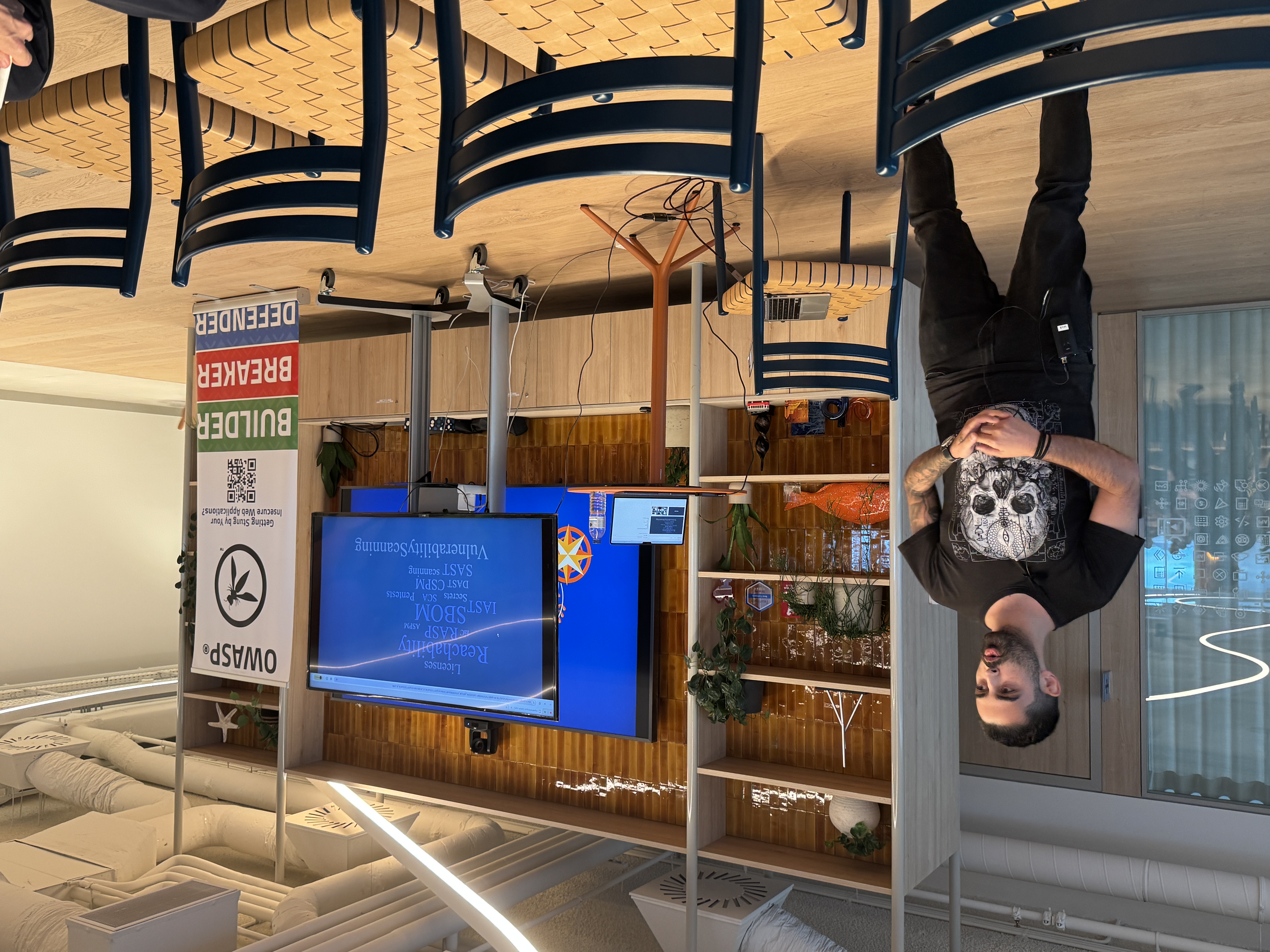 OWASP Lisboa #10 A speaker wearing a skull t-shirt presenting a slide containing a word cloud of security terms like "SBOM," "SAST," and "Vulnerability Scanning."