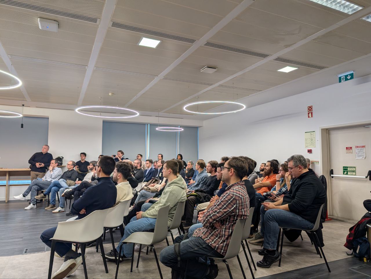 OWASP Lisboa #12 Side view of a focused audience at the Devoteam Cybertrust office during a night of cybersecurity talks and knowledge sharing.
