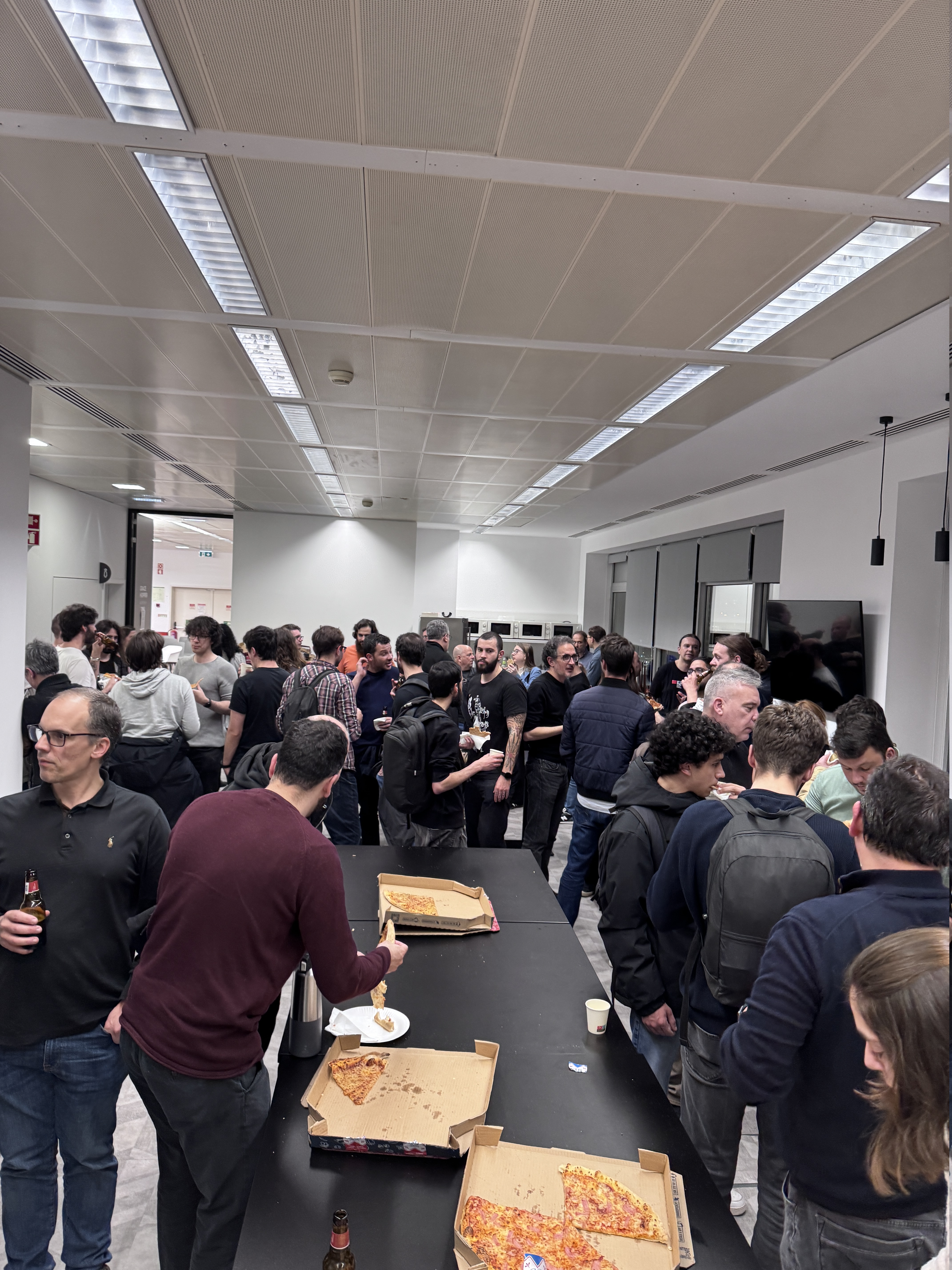 OWASP Lisboa #12 Cybersecurity professionals networking and enjoying a pizza break in the Devoteam office kitchen area after the OWASP Lisboa presentations.