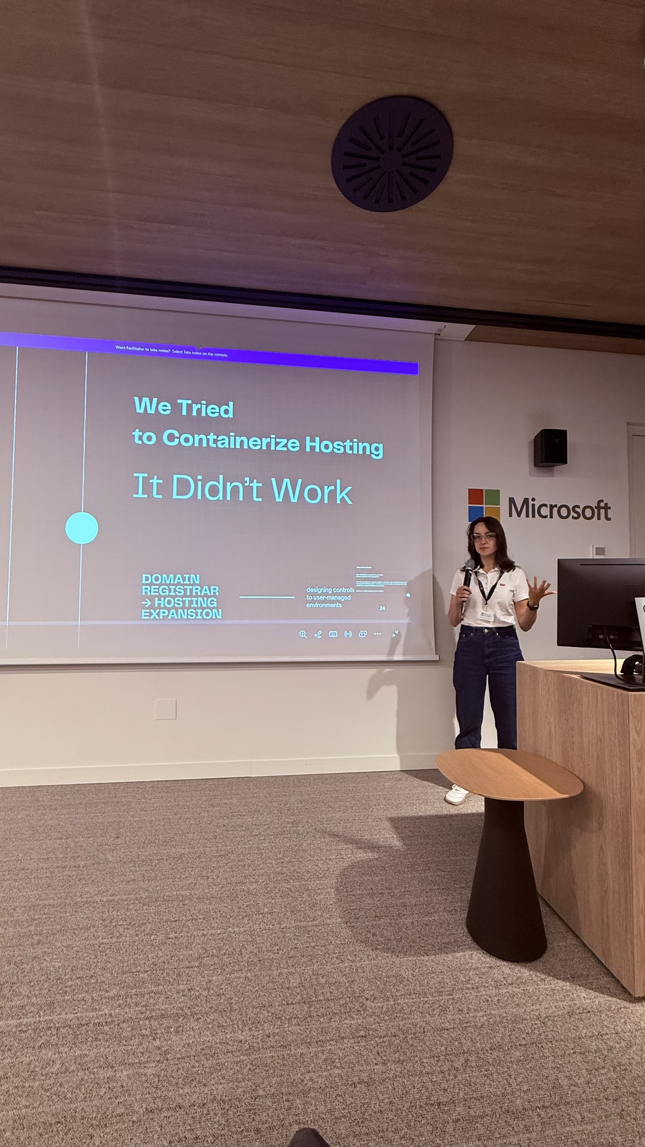 OWASP Lisboa #13 Speaker Uliana Stiagailo presenting her session titled "We Tried to Containerize Hosting – It Didn’t Work" on a large projection screen at the Microsoft offices.
