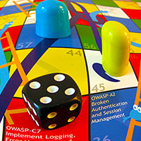 Picture of a die and two markers on an OWASP Snakes and Ladders sheet
